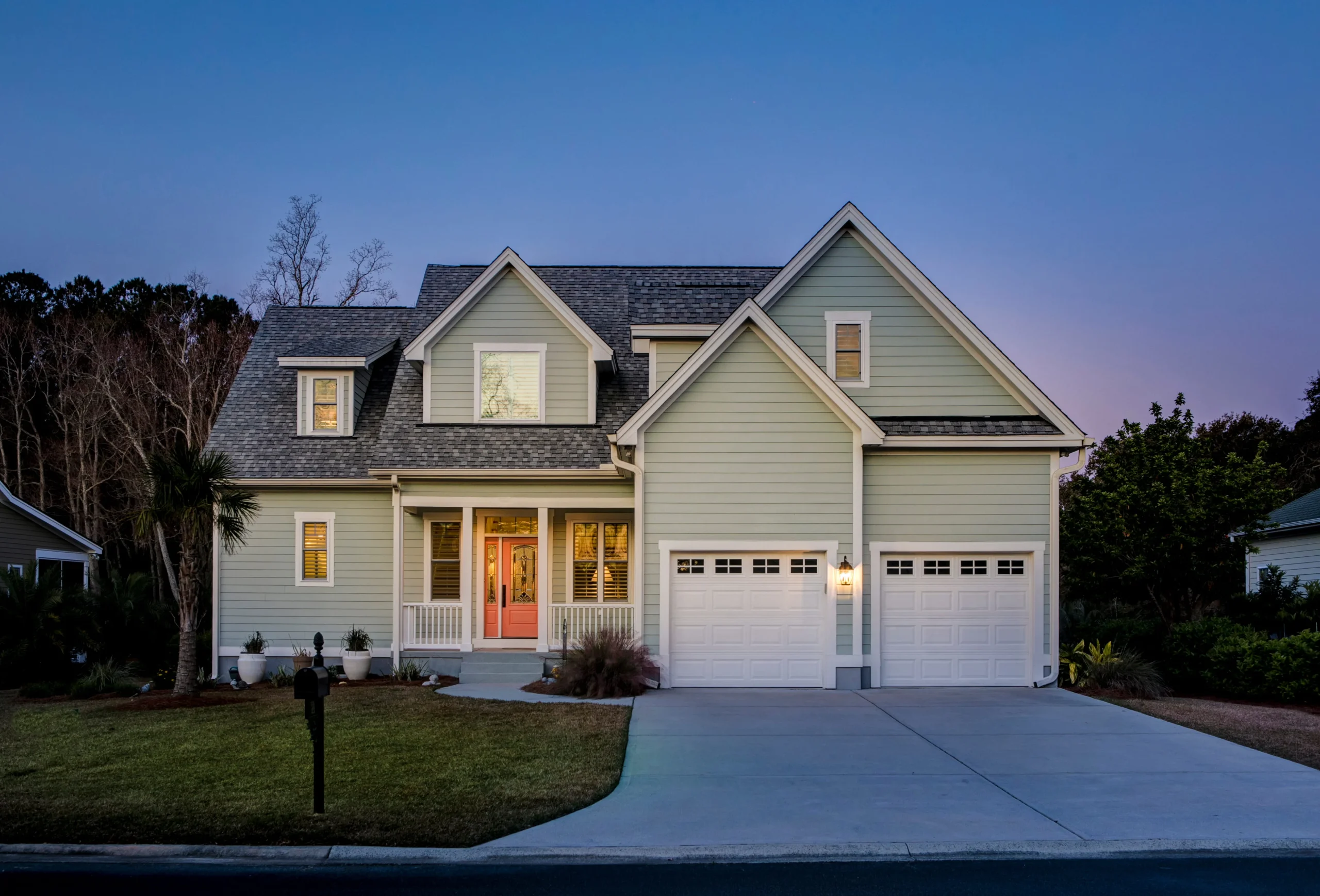 Modern two-story suburban home with a front porch, double garage doors, and a smooth concrete driveway in New York.